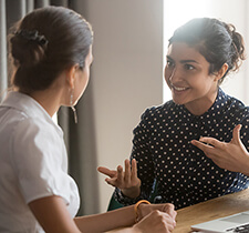 Join Our Team Image: Two business women talking