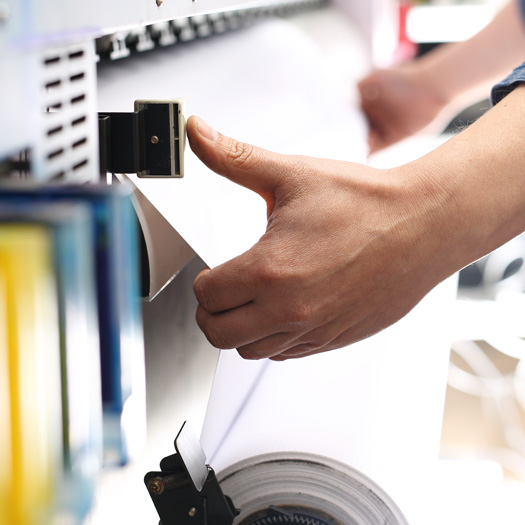 Innovation Person pulling paper out of commercial printer
