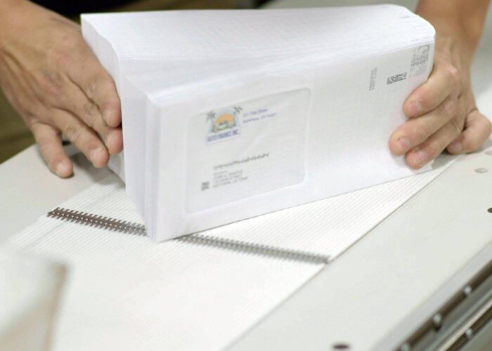 person aligning stacks of mail