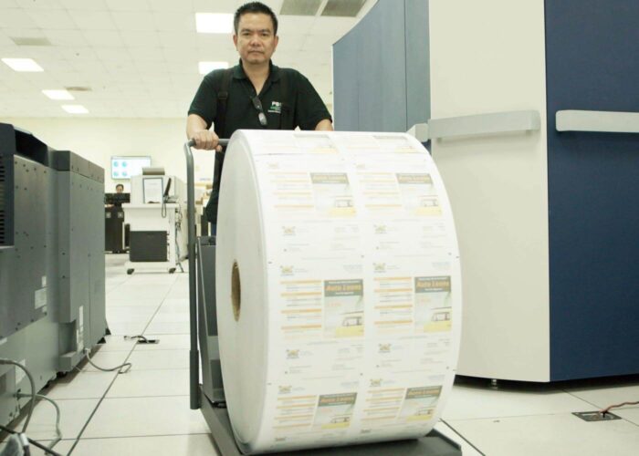 employee rolling huge roll of printed statements