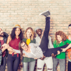 Image: a group of young adults holding up their friend