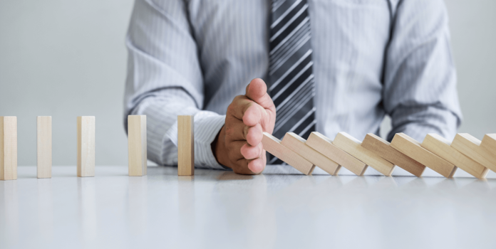 Disaster Recovery Planning as Part of Your Business Continuity Plan Person toppling blocks like dominos
