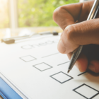 person adding checkmarks to a checklist