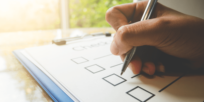 person adding checkmarks to a checklist