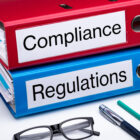 Two binders labeled compliance and regulations