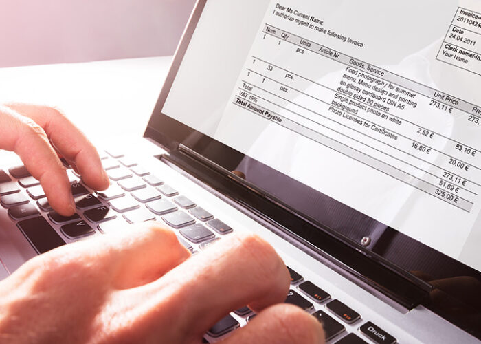 Hands typing on a laptop