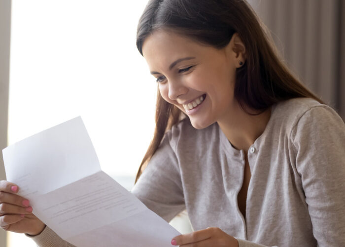 Woman holding letter and smiling
