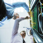 People plugging wires into servers