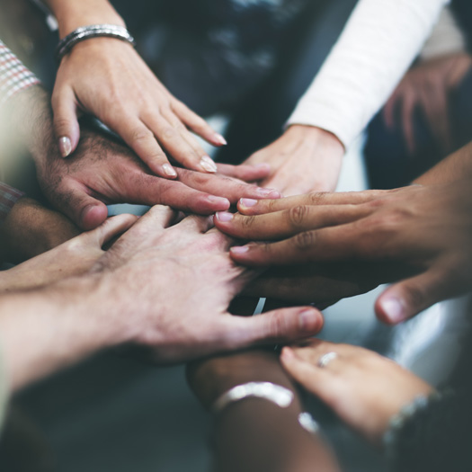 Close-up of many hands touching in a circle