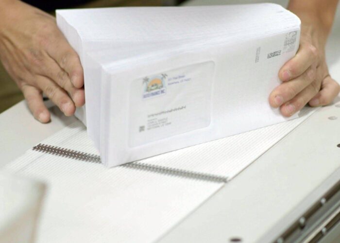 person aligning stacks of mail.