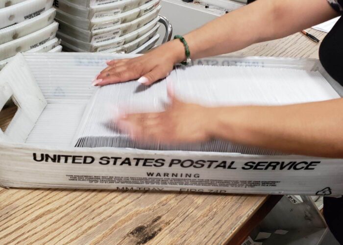 person organizing mail in a tray.