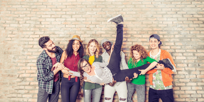 a group of young adults holding up their friend.