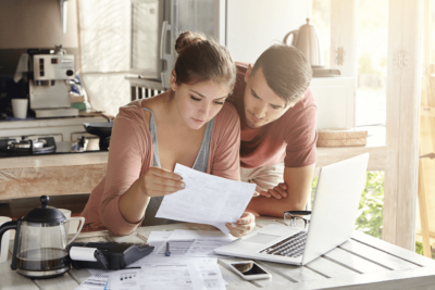 Two people reviewing a statement in front of a computer.