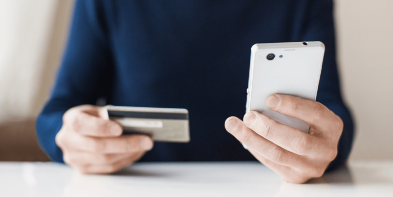 person holding their phone and credit card.