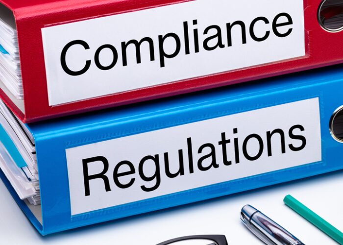 Two binders labeled compliance and regulations.