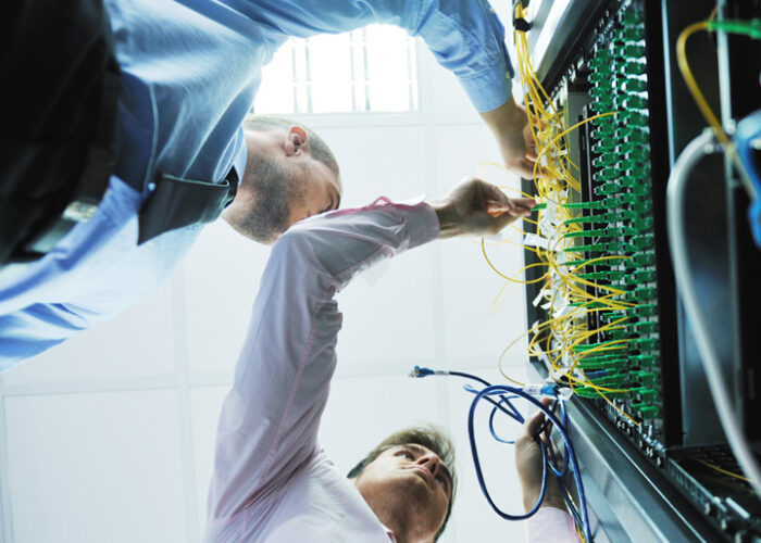 People plugging wires into servers.