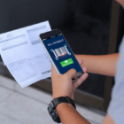 Person Holding a Smartphone Paying a Bill with QR Code.