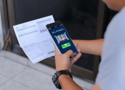Person Holding a Smartphone Paying a Bill with QR Code.